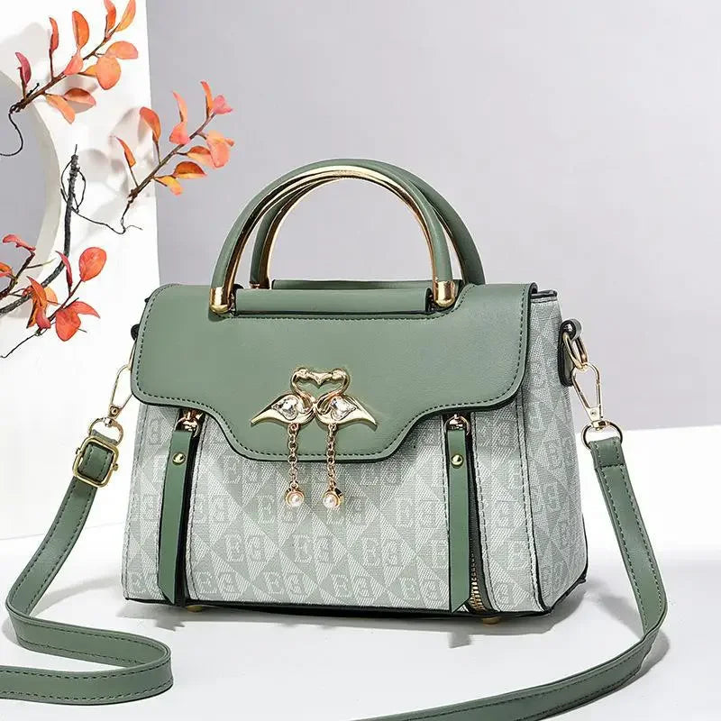 Versatile multi-color handbag features a green top with a cute bird charm, soft material, and optional shoulder strap.