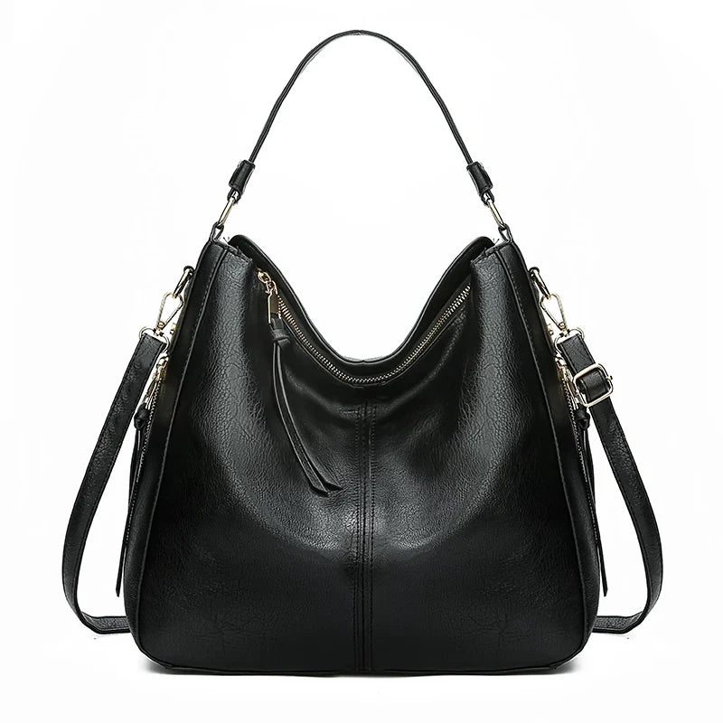 Black faux leather hobo handbag with a single shoulder strap and a zippered top. Smooth finish with a minimalist design.