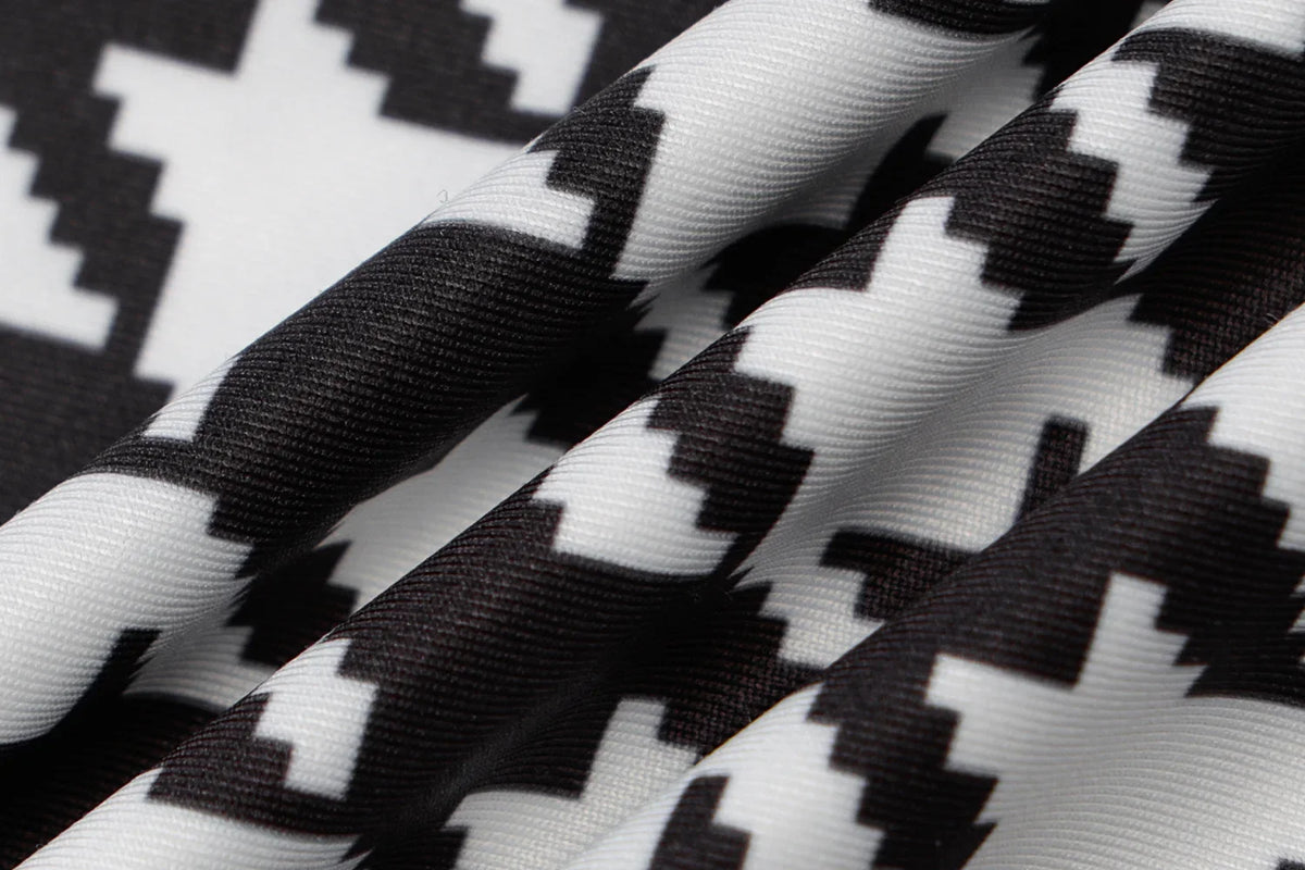 Houndstooth print fabric in black and white, featuring a smooth texture and a vibrant, bold pattern.