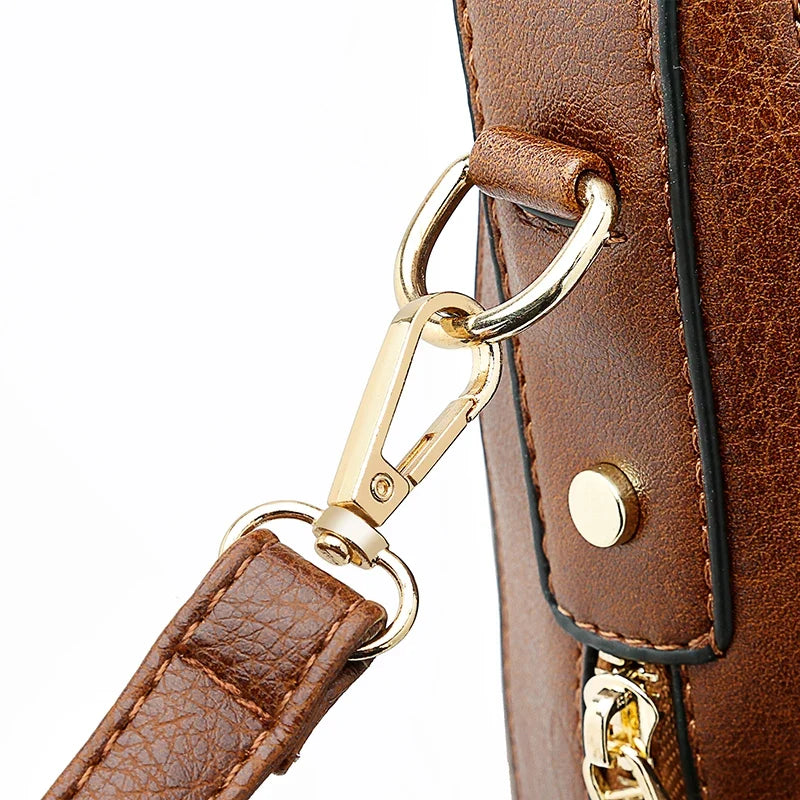 Brown faux leather handbag with a gold metal clip and strap attachment, designed for casual use.