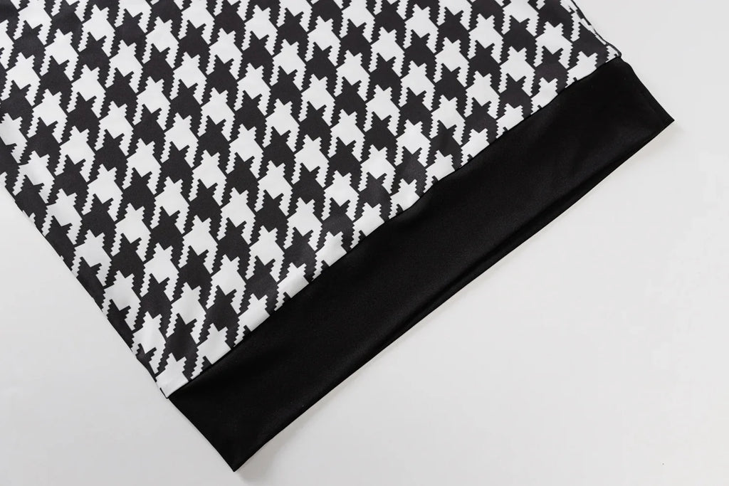 Houndstooth print fabric in black and white with a solid black hem, showcasing a casual, stylish design.