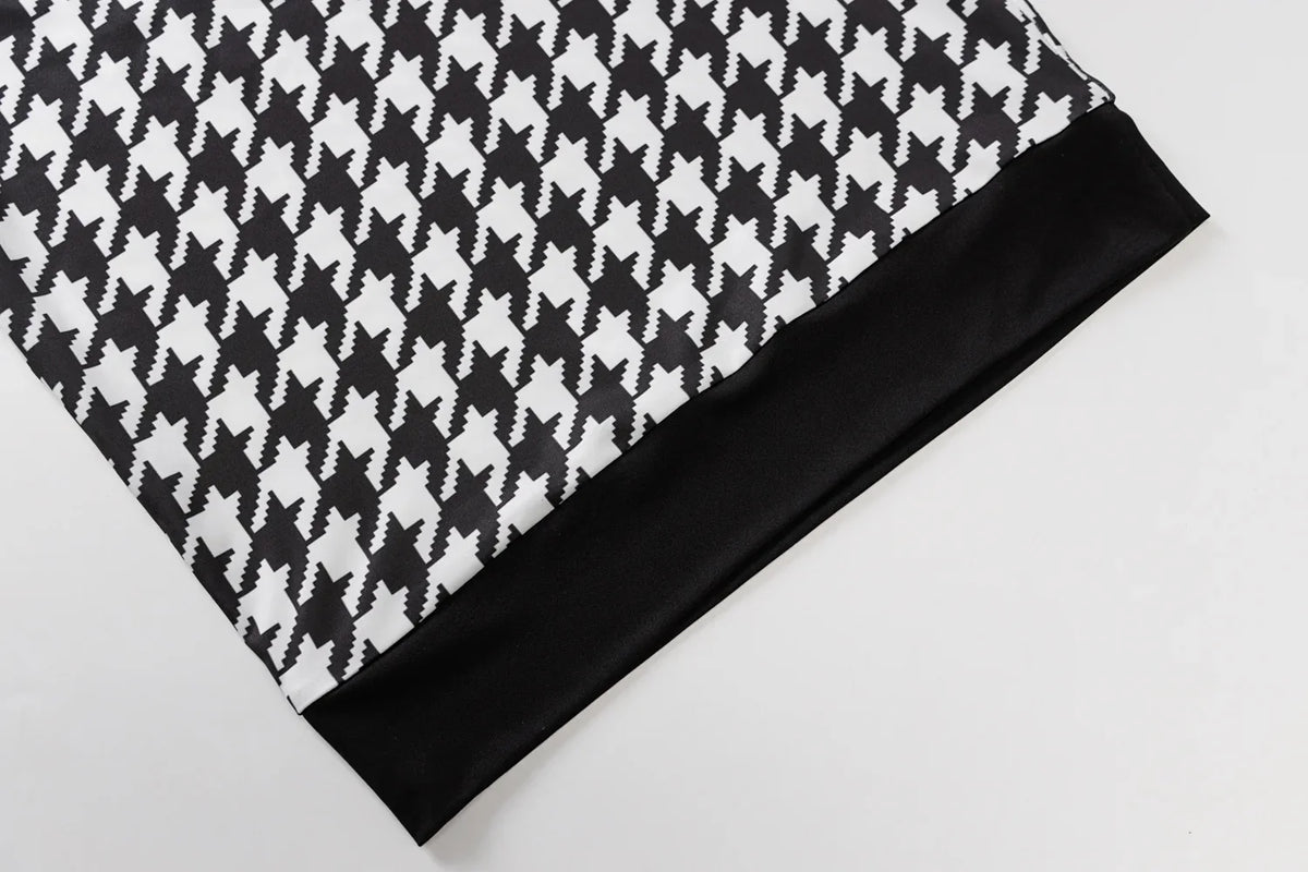 Houndstooth print fabric in black and white with a solid black hem, showcasing a casual, stylish design.