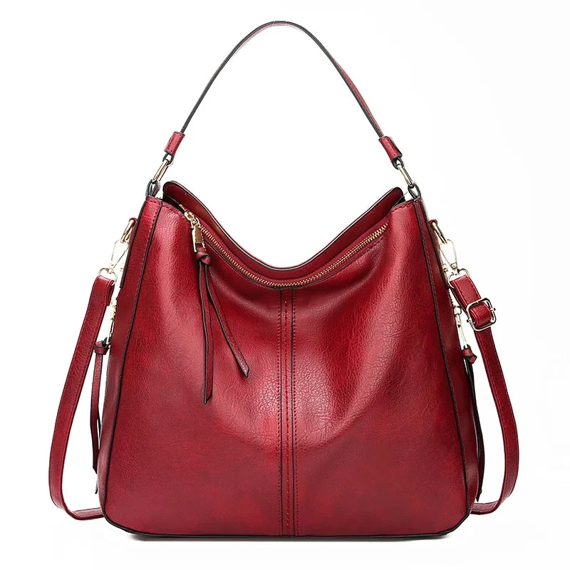 Large burgundy faux leather hobo bag with a zipper closure and adjustable shoulder strap. Casual style, soft texture.