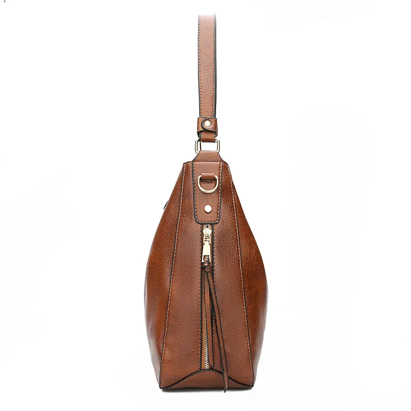 Brown faux leather hobo handbag with a single shoulder strap and a zipper closure, featuring a sleek, casual design.