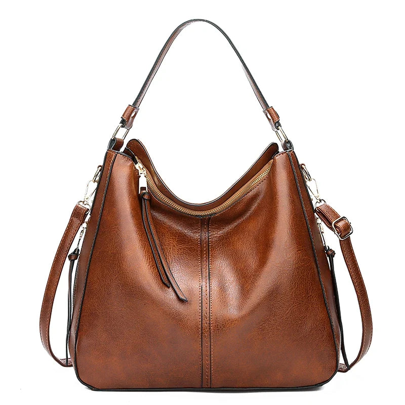 Brown faux leather hobo handbag with a single shoulder strap and zipper closure, featuring a smooth finish and subtle stitching.