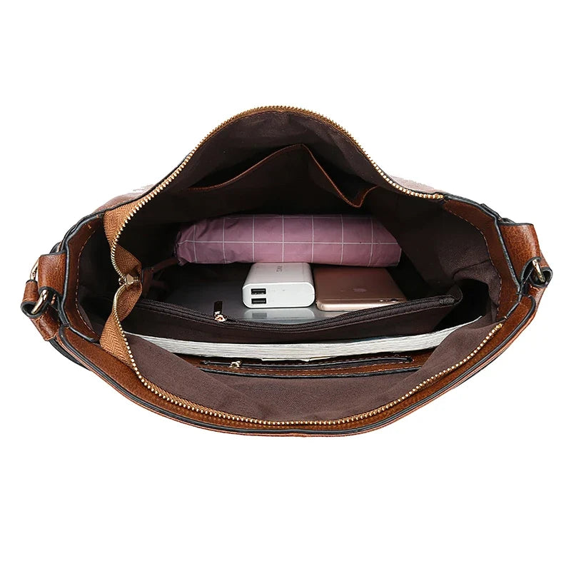Interior view of a brown faux leather handbag showing a zipper closure, an interior compartment, and multiple pockets.