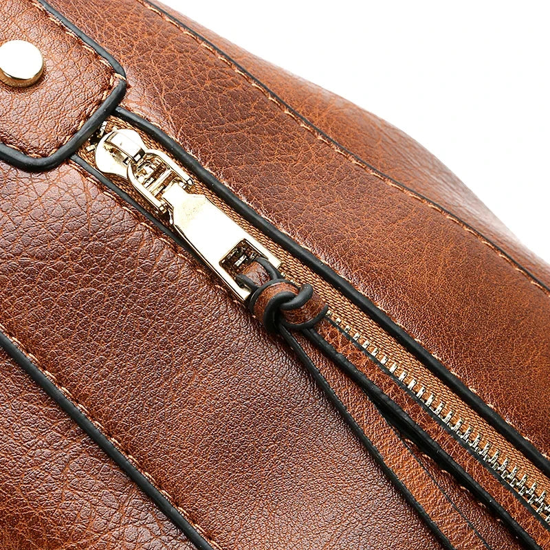 Brown faux leather handbag with a zipper closure, featuring a textured finish and gold-tone hardware.