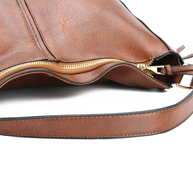 Brown faux leather hobo handbag with a zipper closure and a single shoulder strap, featuring a soft texture.