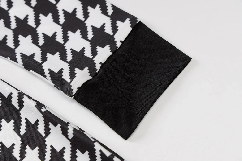 Houndstooth print fabric featuring black and white patterns with solid black cuffs. Perfect for stylish layering.