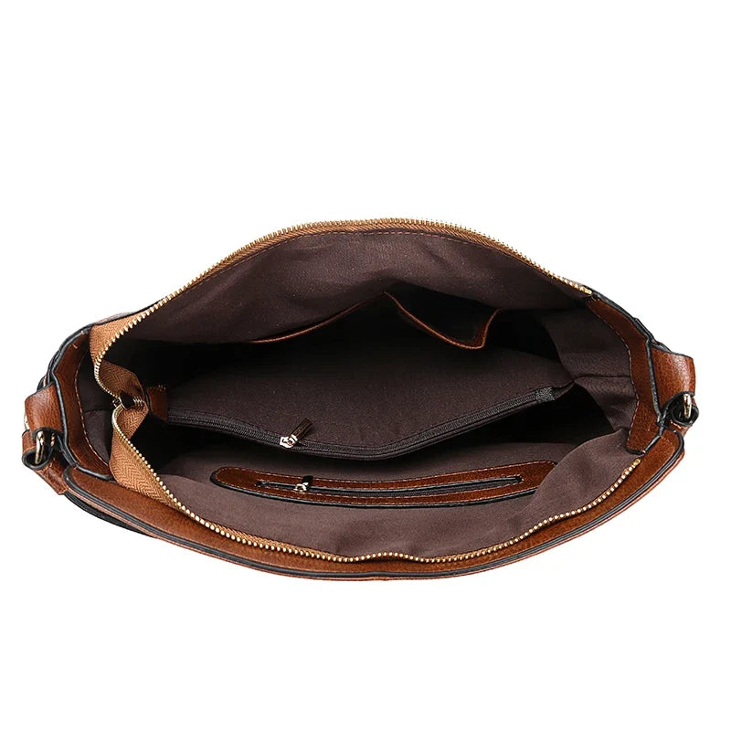 Brown faux leather handbag with a soft structure, featuring a zipper closure and multiple interior pockets.