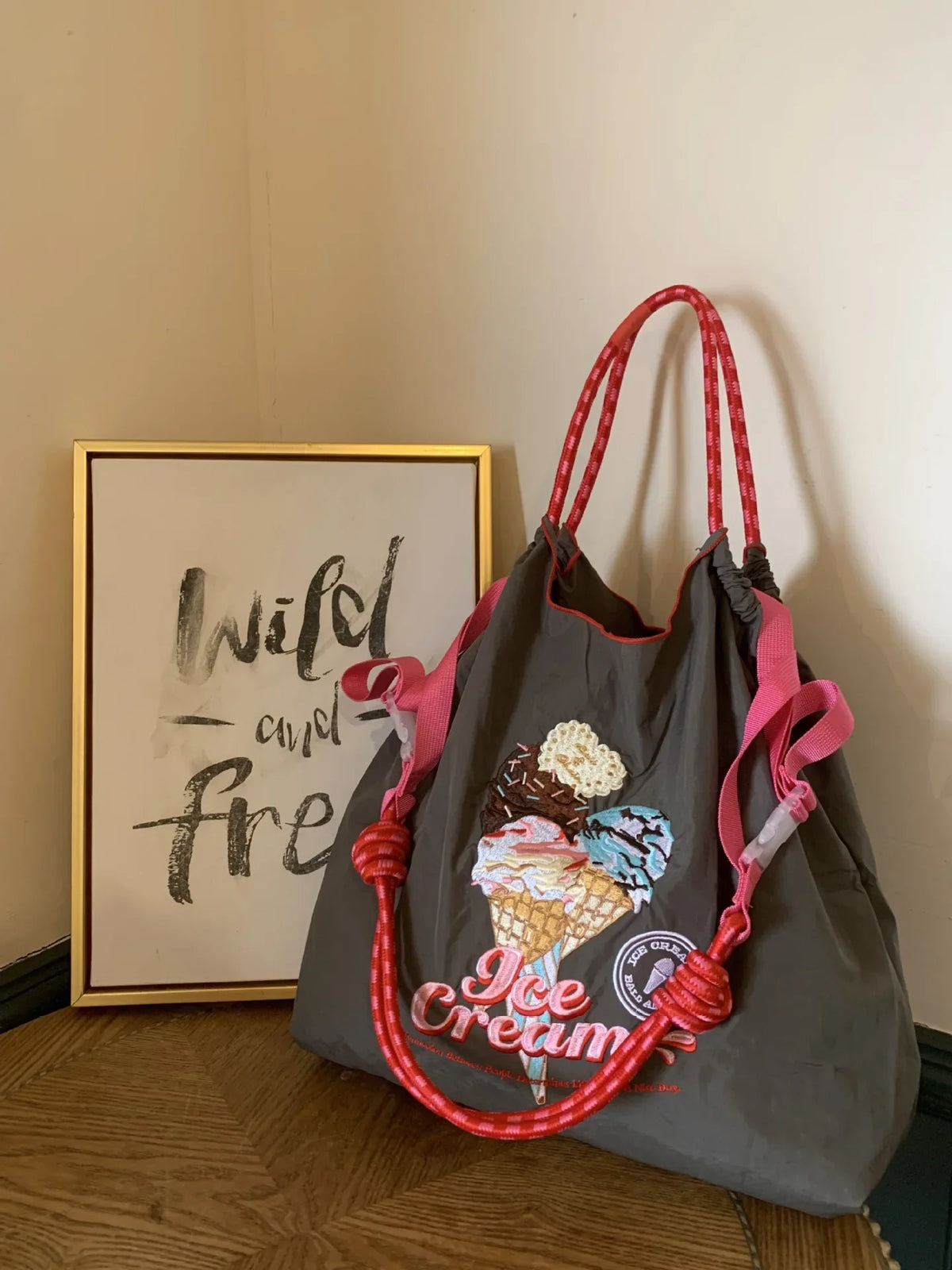 Large grey nylon tote bag with pink handles, featuring an embroidered ice cream design and a casual style.