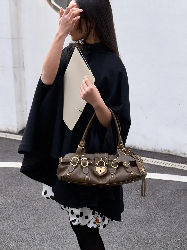 Brown microfiber synthetic leather handbag featuring gold-tone rivets and a heart-shaped lock, styled as a crossbody.