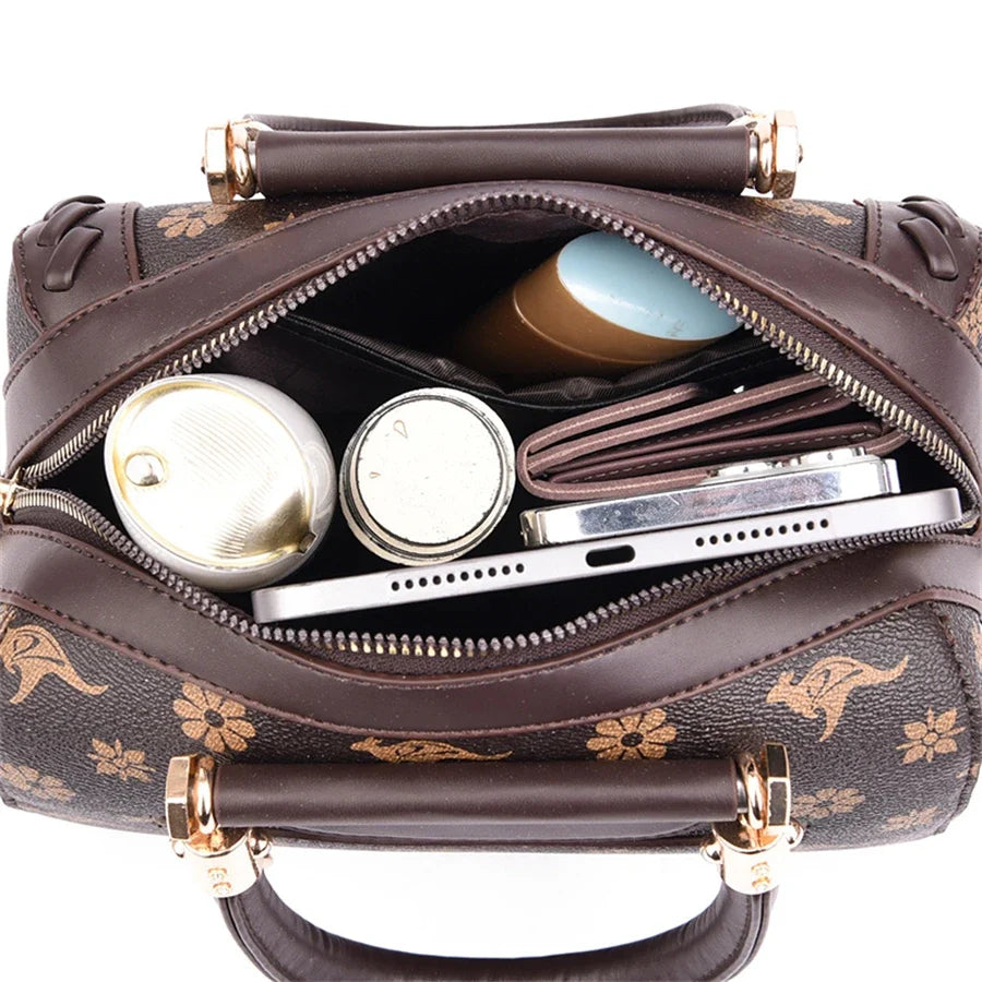 Top view of a brown designer shoulder bag featuring a zipper closure, showing various items inside, including skincare products and a wallet.