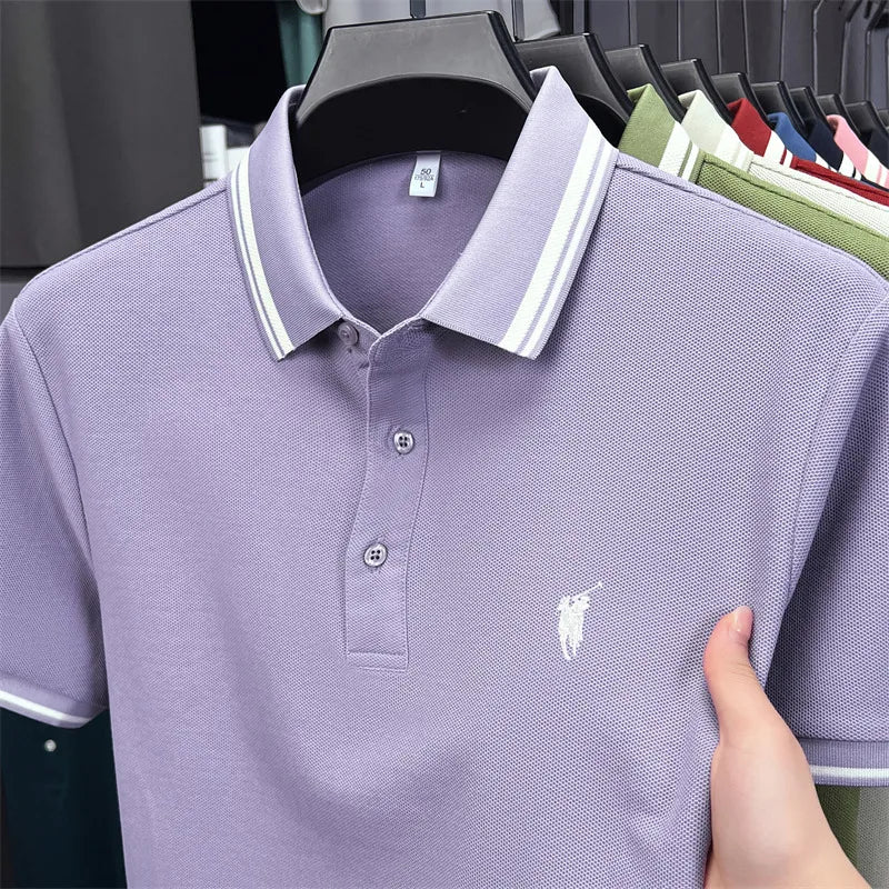 Short sleeve polo shirt in light purple with white striped collar and pony embroidery, hanging from a rack.