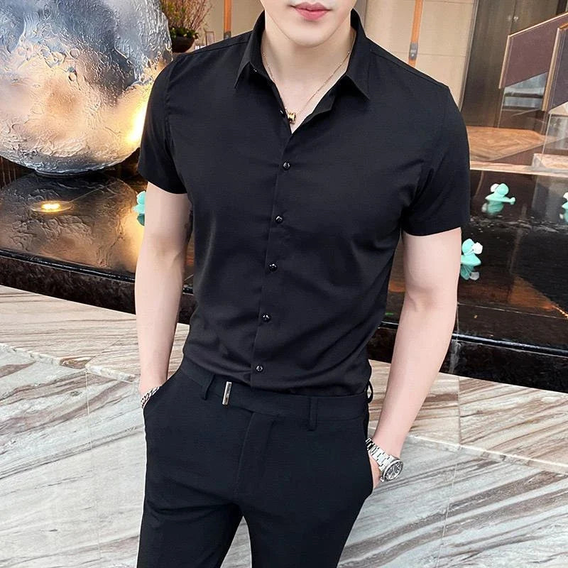 Black short-sleeve button-up shirt with a square collar, worn tucked into tailored black pants.