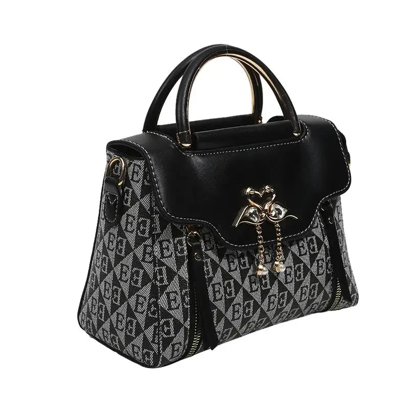 Black and gray handbag with diamond pattern, gold accents, and a structured shape. Features dual top handles and zip closures.