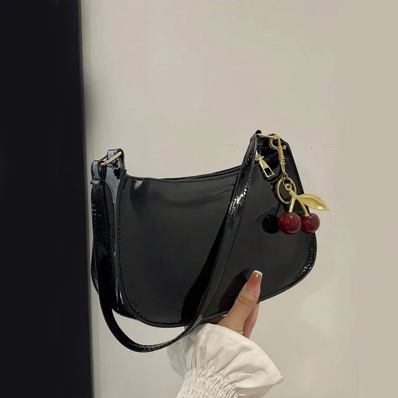 Women's pure leather cherry pendant handbag by TrendLux Wear featuring a solid color design and a stylish cherry pendant detail.