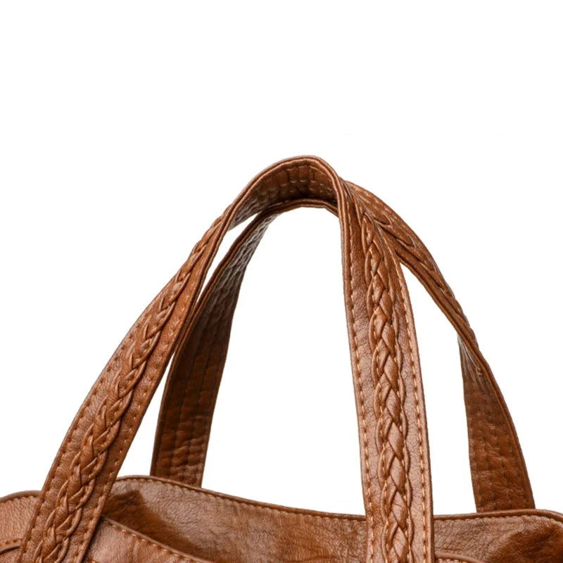 Brown leather shoulder bag with braided straps and a soft finish, designed as a casual tote for versatile use.