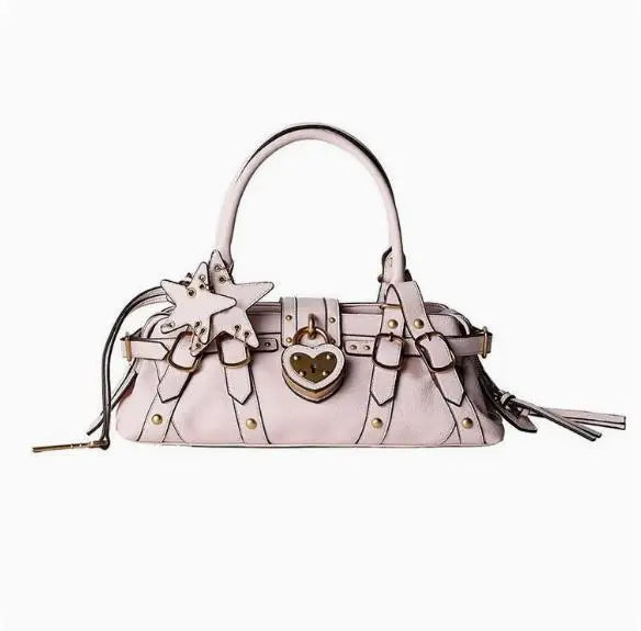 Soft pink handbag featuring star and heart appliques, zip closure, and a single shoulder strap for crossbody wear.