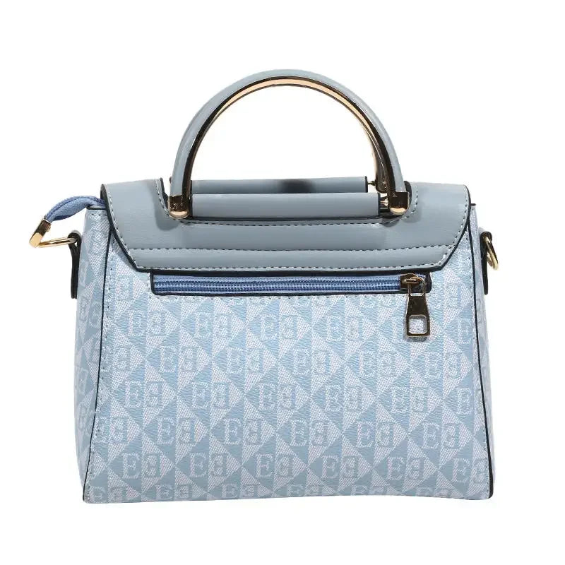 Light blue embossed handbag with a top handle and detachable shoulder strap, featuring a rectangular shape and gold accents.