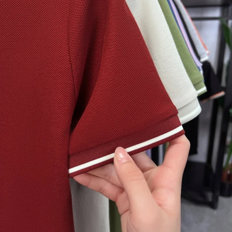 Short sleeve polo shirt in deep red, featuring a textured fabric and white stripe detailing on the cuffs.