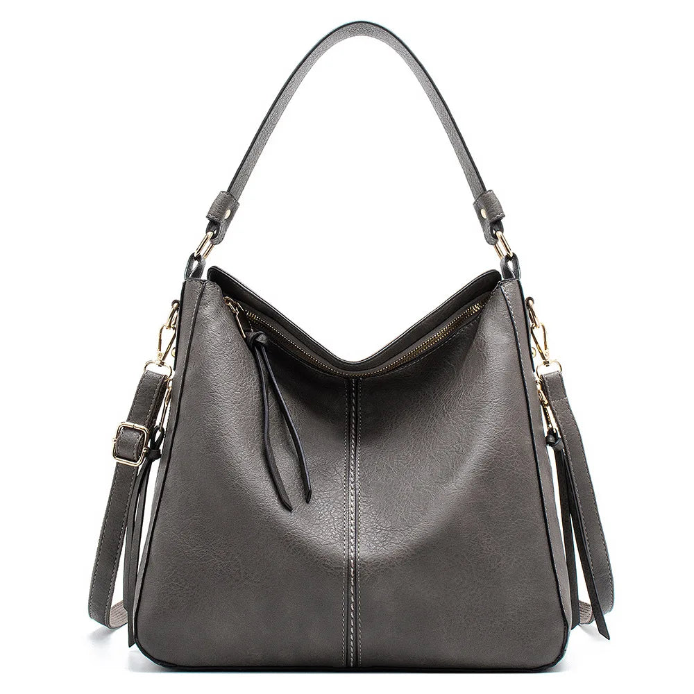 Large gray faux leather hobo bag with a single shoulder strap and a zipper closure, featuring a smooth textured finish.