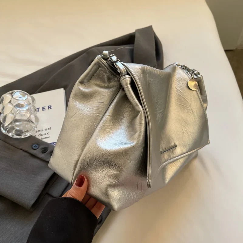 Silver shoulder bag with a soft leather finish, featuring a large capacity and two handles, styled as a casual tote.