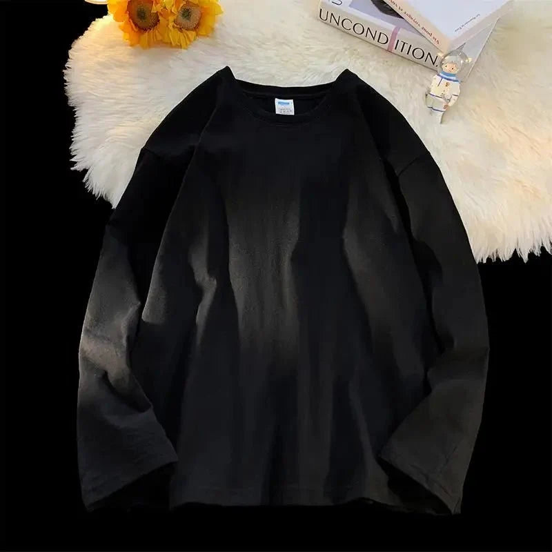 Unisex oversized long sleeve blank T-shirt by My Store 5 in black, displayed on a hanger against a white background.