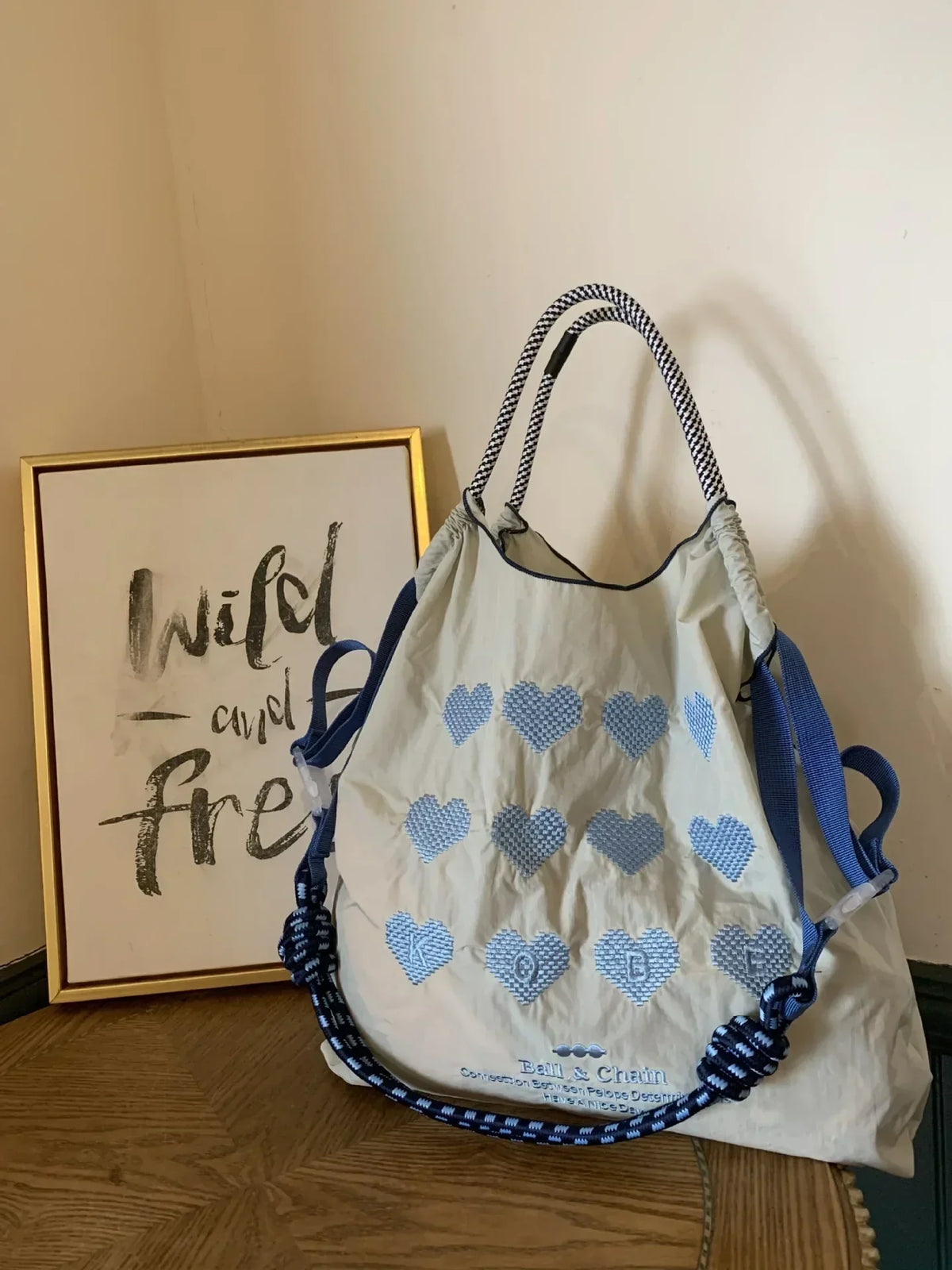 Lightweight nylon tote bag with blue heart embroidery, featuring blue rope handles and a casual design for versatile use.