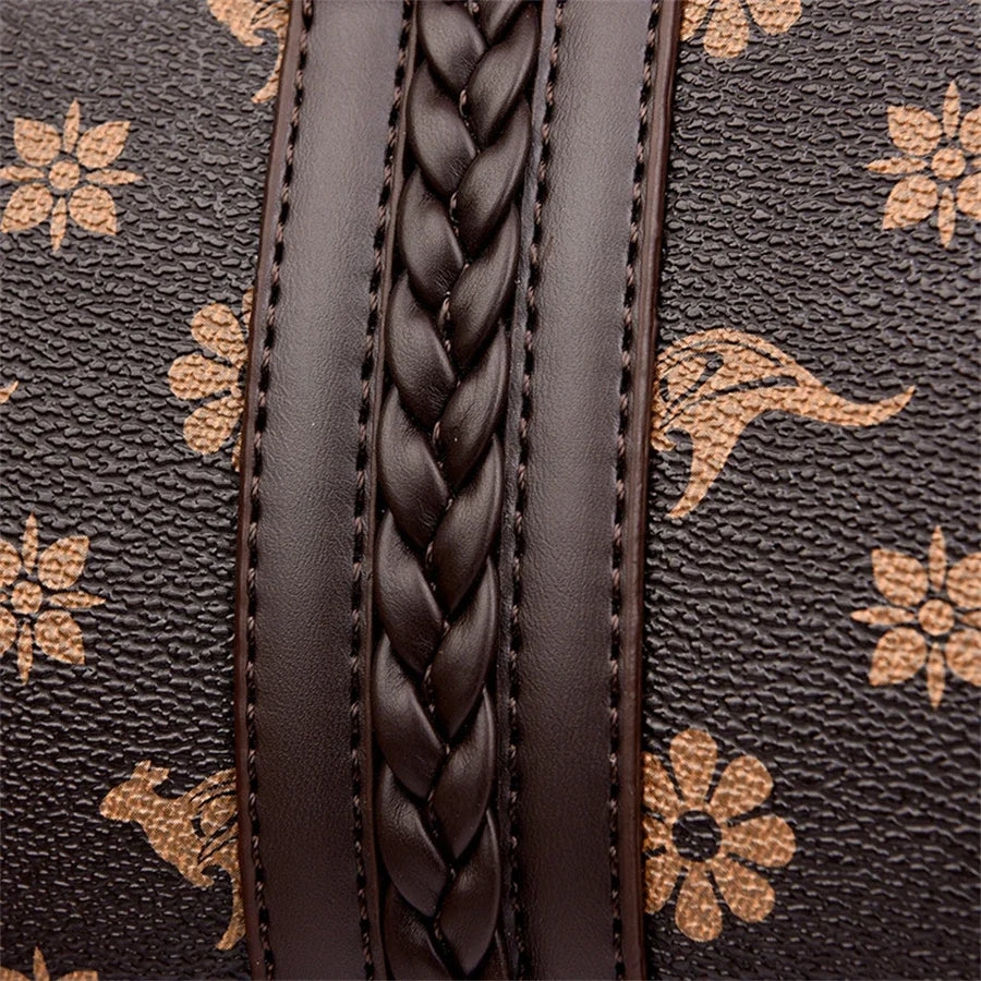Brown leather handbag with floral and animal print, featuring a braided strap and textured surface.