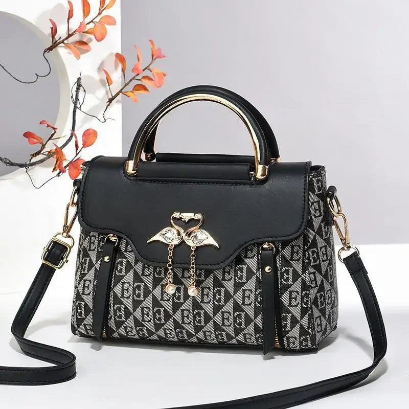 Versatile black and gray handbag with a heart detail, soft texture, and a detachable shoulder strap.