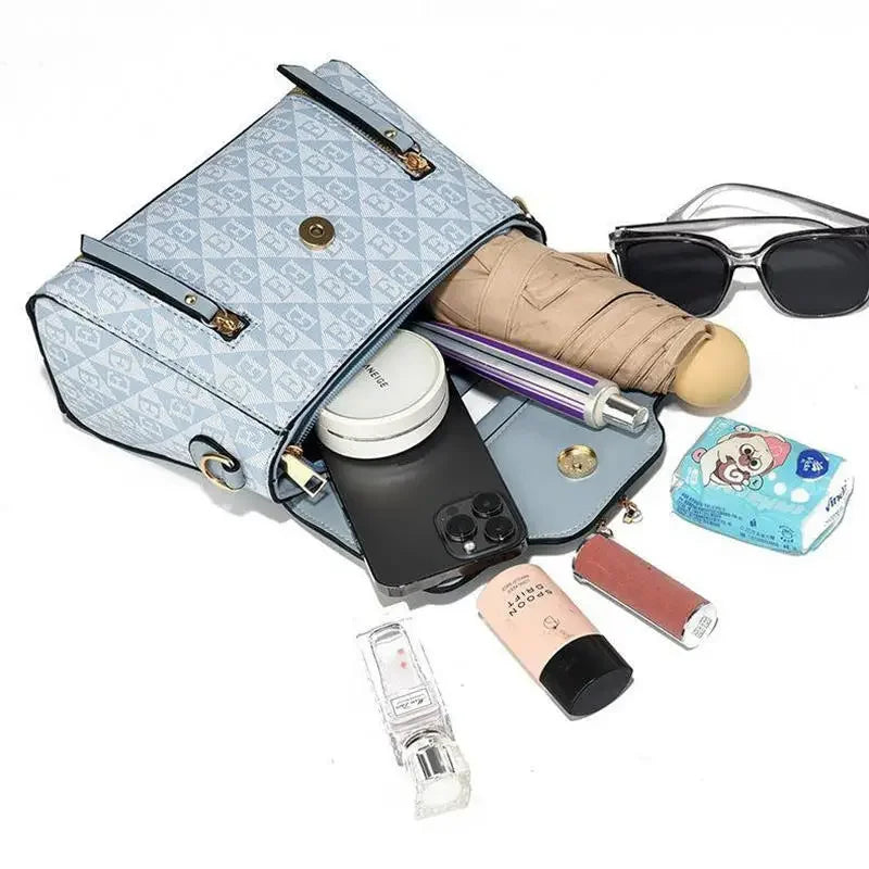 Versatile blue handbag with a diamond embossed pattern, featuring a spacious interior with various personal items visible.