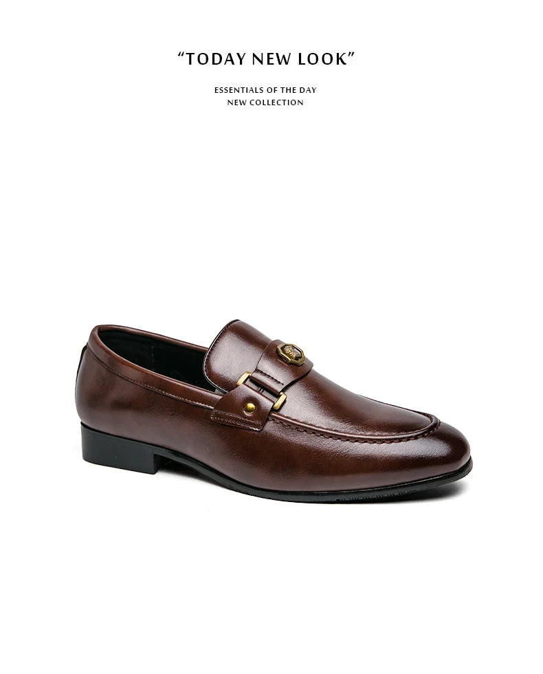 Brown leather slip-on loafers with a round toe, featuring a metal buckle detail and stitched accents.