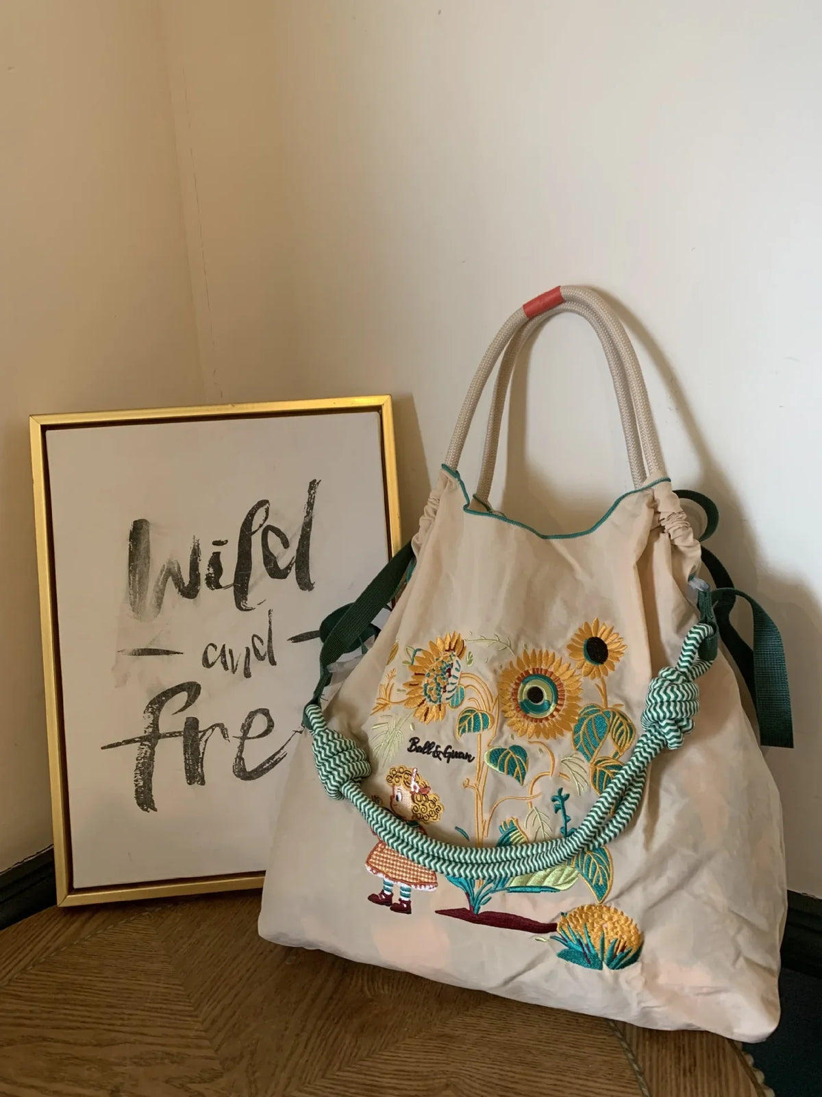 Nylon tote bag featuring colorful sunflower embroidery, large-capacity design, and green braided handles.