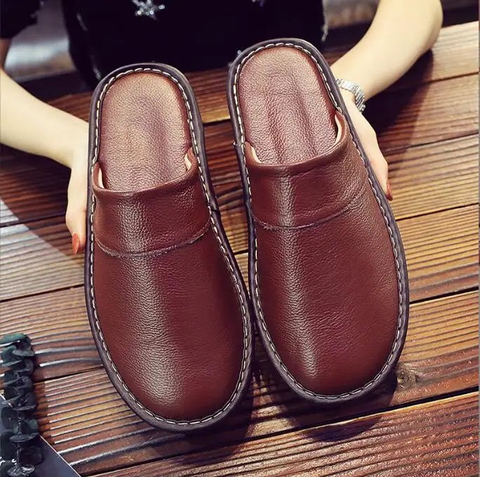 Unisex leather indoor slippers by TrendLux Wear with non-slip soles, available in EU sizes 35 to 46, shown on a wooden floor.