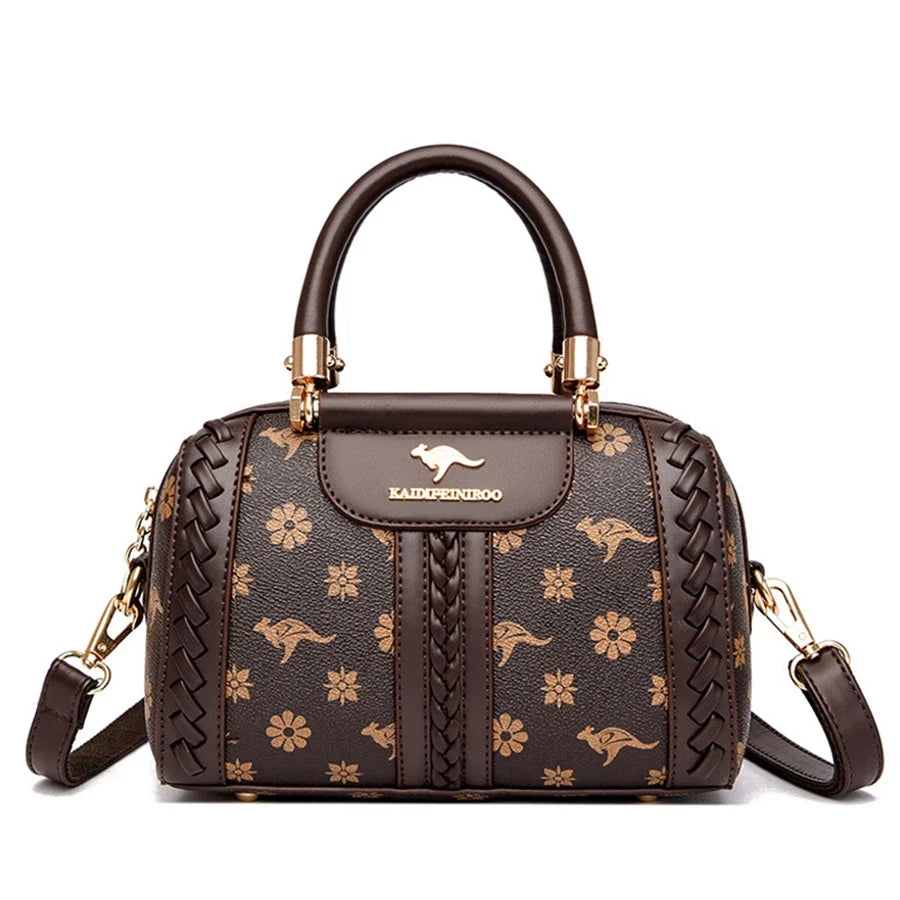 Brown semi-woven handbag with floral and kangaroo patterns, gold accents, and a detachable shoulder strap.