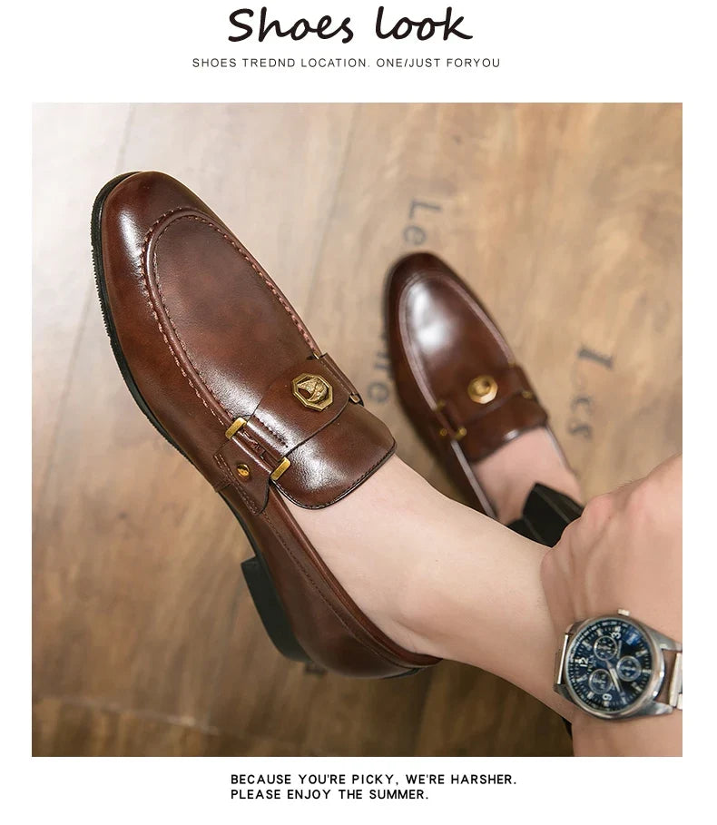 Brown leather slip-on loafers with a round toe and gold-tone metal buckle detail, styled for casual elegance.