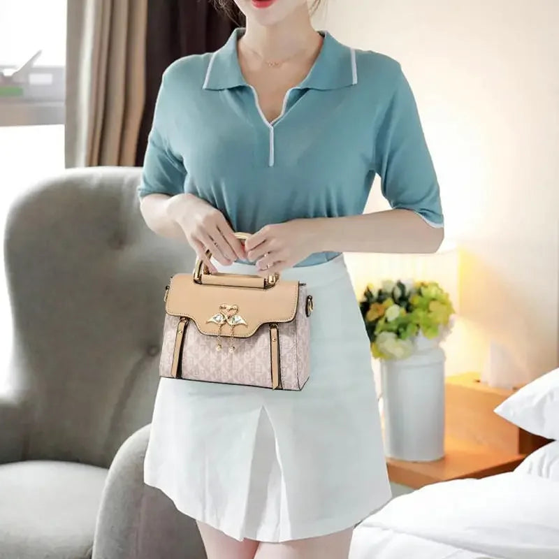 Versatile casual shoulder crossbody handbag in embossed light pink with a gold-tone clasp, styled with a polo and skirt.