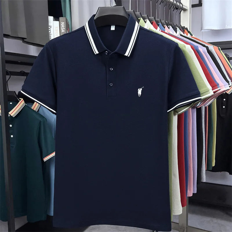 Navy blue short sleeve polo shirt with white striped collar and embroidered pony logo, displayed among various other shirts.