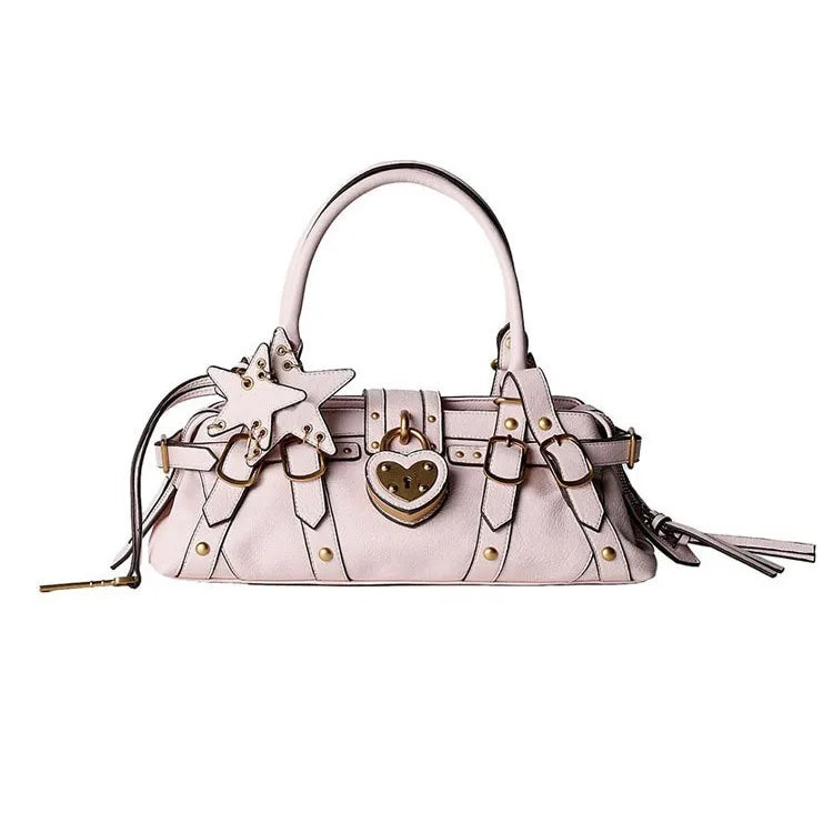 Stylish pink handbag with decorative star and heart charms, featuring rivet details and a zipper closure.