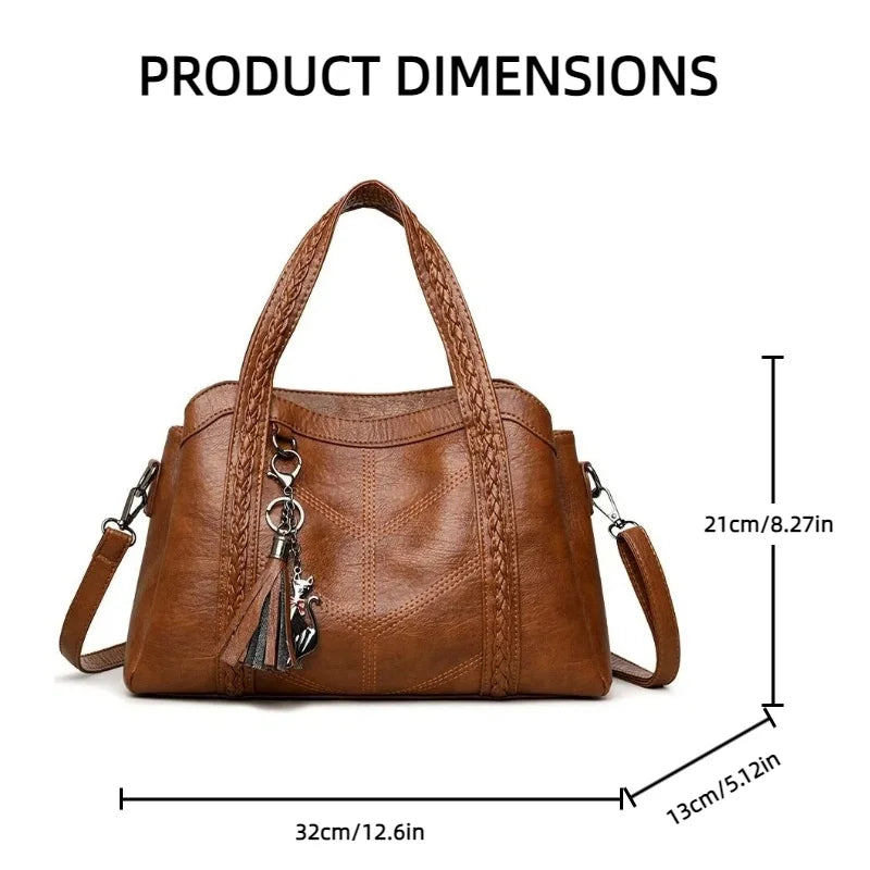 Brown leather shoulder bag with braided handles, side tassel detail, and a casual tote shape. Dimensions: 32cm x 21cm x 13cm.