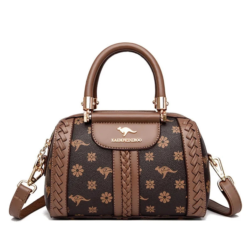 Brown shoulder handbag featuring floral and kangaroo patterns, braided detailing, and an adjustable strap.