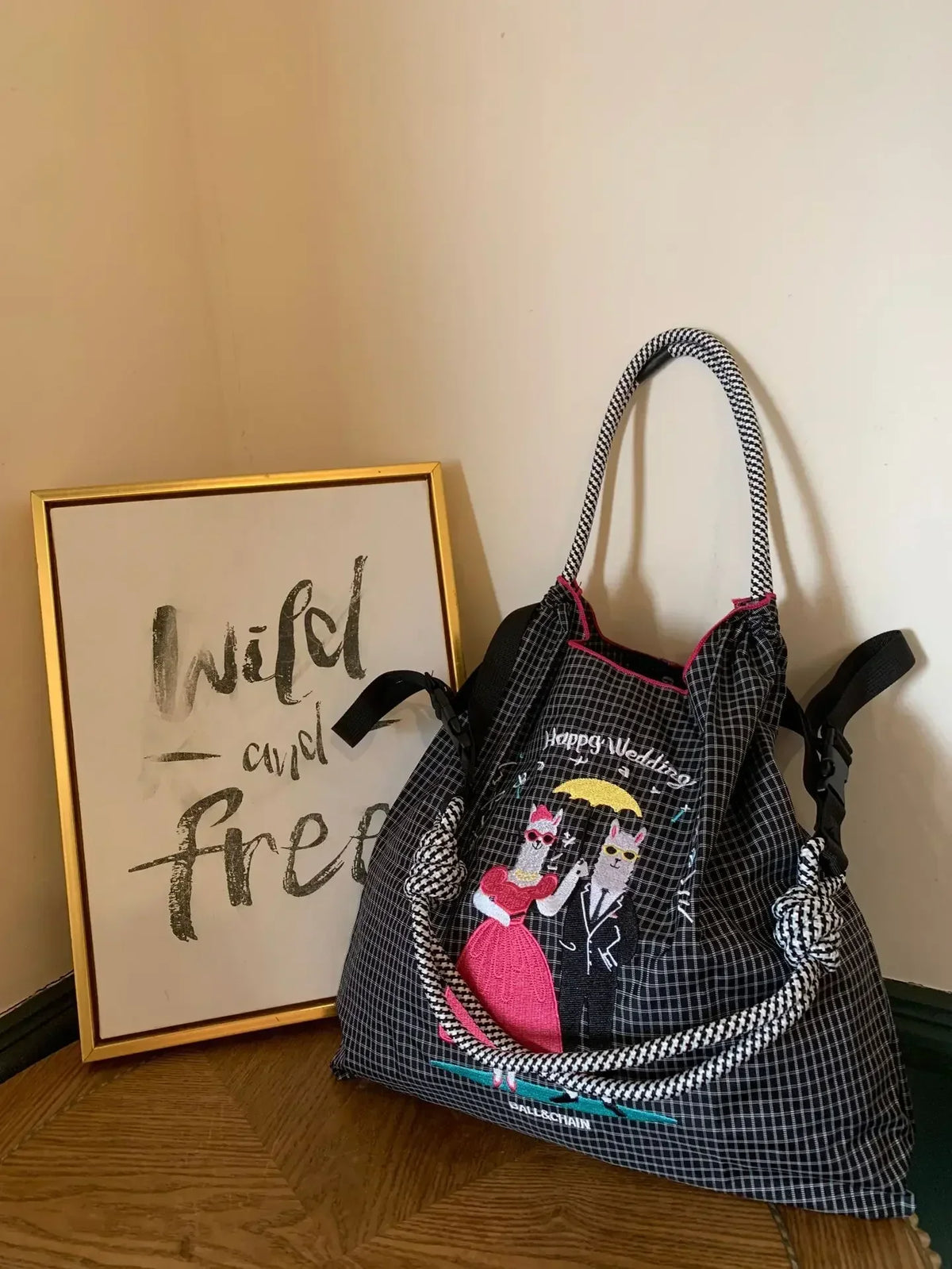 Large-capacity nylon tote bag featuring a fun embroidered couple design in pink and black, with dual shoulder straps.