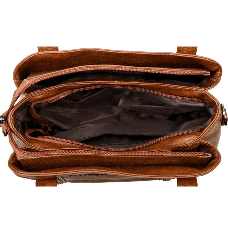 Brown leather shoulder bag featuring multiple compartments, zip closures, and a soft, casual tote design.