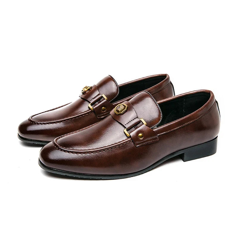 Brown leather slip-on loafers featuring a metal buckle and round toe design, suitable for formal and casual occasions.