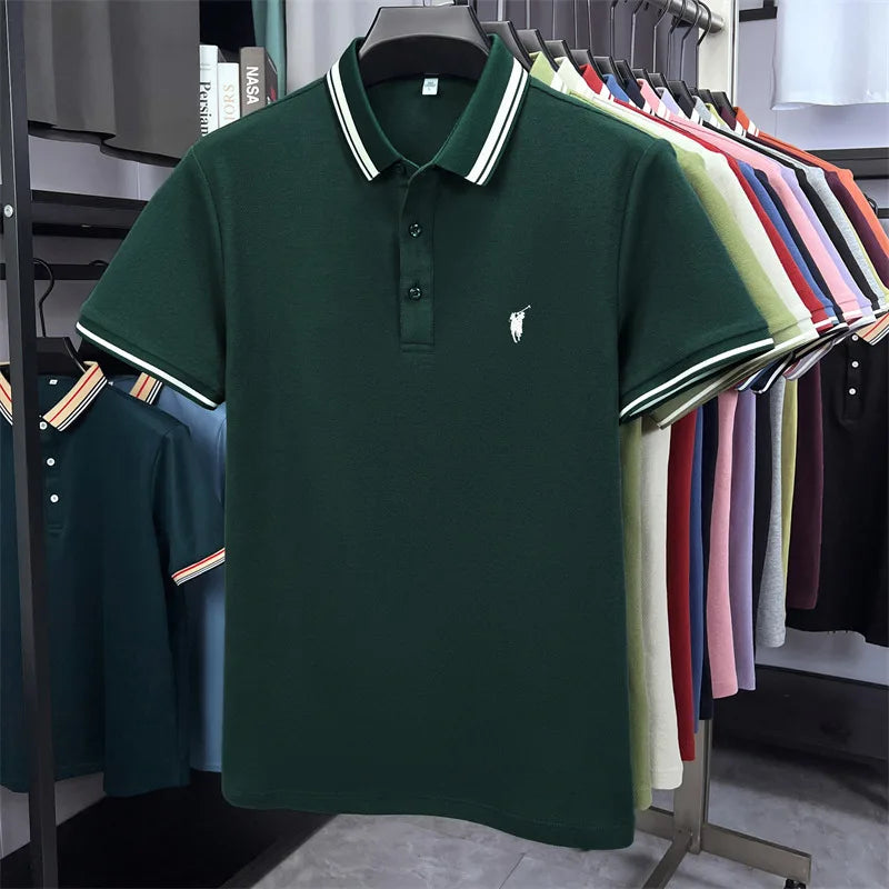 Dark green short sleeve polo shirt with white striped collar and small embroidered logo, hanging among assorted colors.