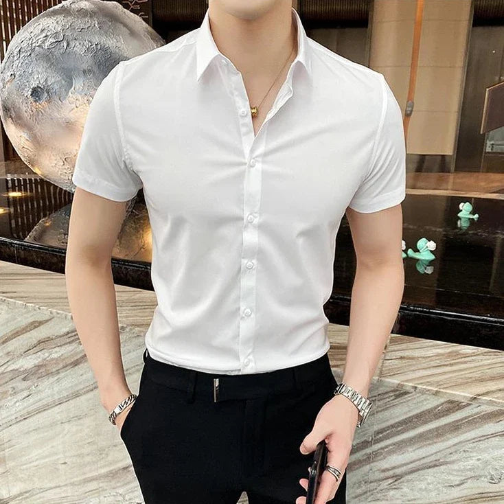 Short-sleeve white shirt with a square collar, tailored fit, worn tucked into dark pants.