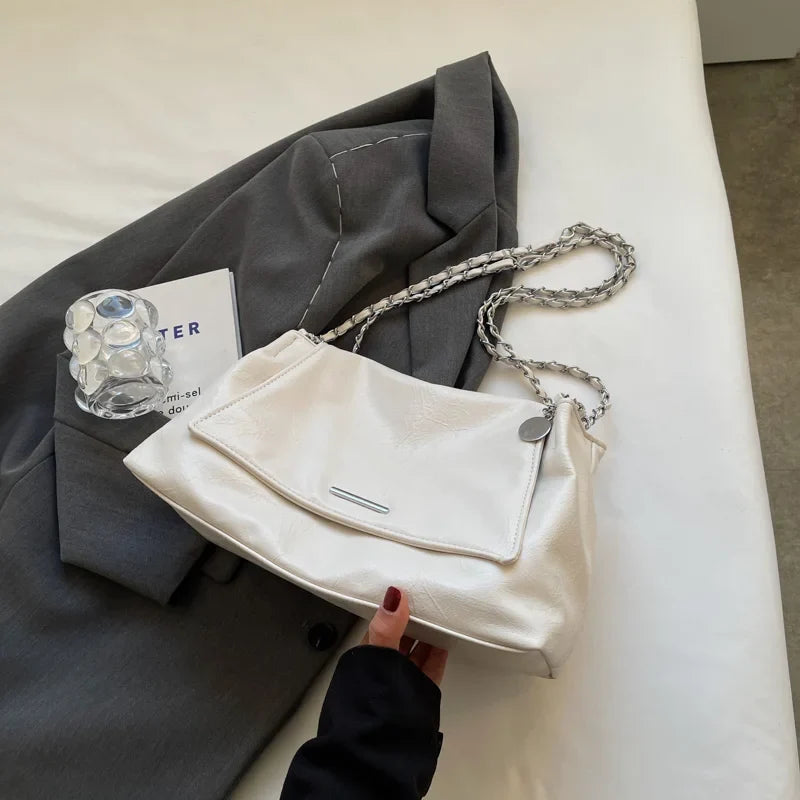 Soft white leather shoulder bag with a chain strap, featuring a flap pocket and a casual tote shape.