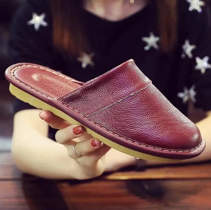 Unisex leather indoor slippers from TrendLux Wear with non-slip soles, available in EU sizes 35 to 46, shown on a wooden floor.