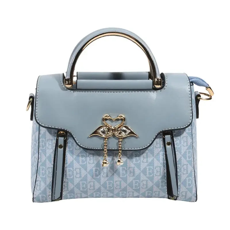 Light blue handbag with a gold heart-shaped clasp, featuring a rectangular shape and dual handles.